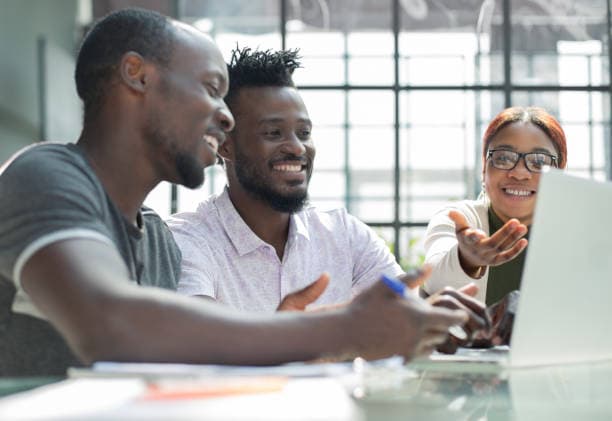 black people talking together with laptop